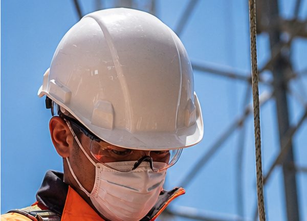 Trabajador utilizando casco, lentes y elementos de protección personal certificados para trabajos en altura